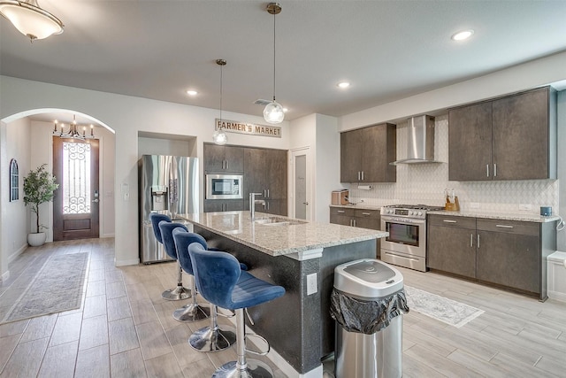 1112 Goldenrod Dr, Godley, TX 76044 - kitchen with stainless steel appliances, wall chimney range hood, a sink, dark brown cabinetry, and recessed lighting