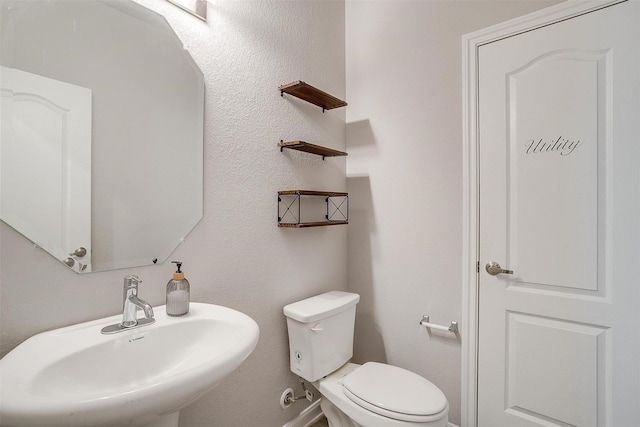 1112 Goldenrod Dr, Godley, TX 76044 - half bathroom featuring a sink, toilet, and baseboards