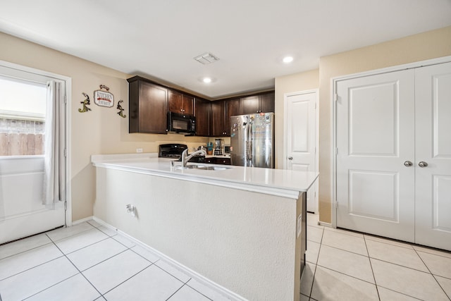 3350 Margay Run, Crandall, TX 75114 - kitchen featuring black microwave, freestanding refrigerator, dark brown cabinetry, light tile patterned floors, and light countertops