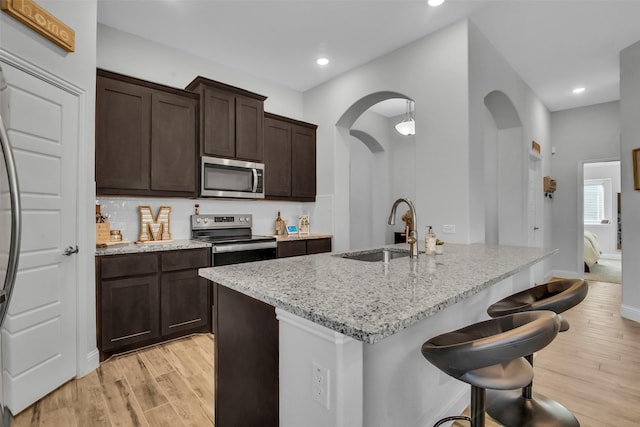 2309 Normandy Ave, Anna, TX 75409 - kitchen featuring stainless steel appliances, a sink, light stone counters, light wood-style flooring, and recessed lighting