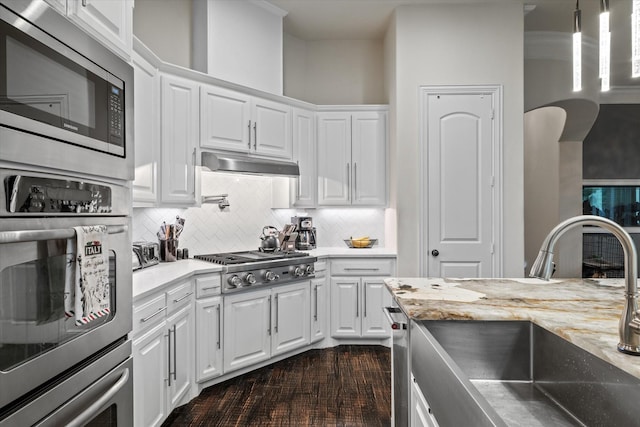 6500 Lazy Oak Ln, Plano, TX 75024 - kitchen featuring stainless steel appliances, a sink, white cabinets, tasteful backsplash, and under cabinet range hood