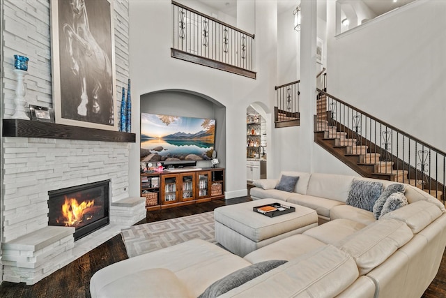 6500 Lazy Oak Ln, Plano, TX 75024 - living room with wood finished floors, a stone fireplace, stairs, baseboards, and a towering ceiling