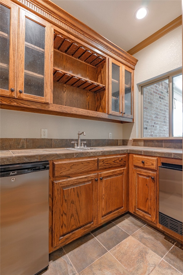 2454 Savanna Cir, Midlothian, TX 76065 - kitchen with dishwasher, a sink, brown cabinets, crown molding, and glass insert cabinets