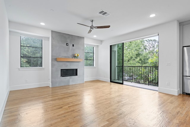 4133 Emerson Ave Unit 1, University Park, TX 75205 - unfurnished living room featuring wood finished floors, a tiled fireplace, ceiling fan, baseboards, and recessed lighting