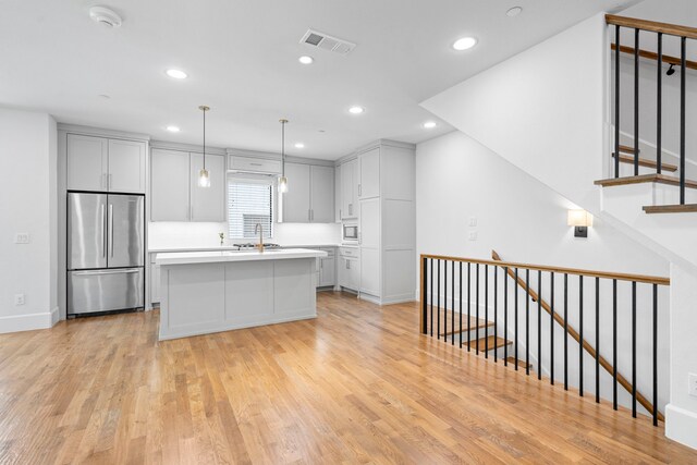 4133 Emerson Ave Unit 1, University Park, TX 75205 - kitchen with appliances with stainless steel finishes, recessed lighting, light wood-style floors, a kitchen island, and light countertops