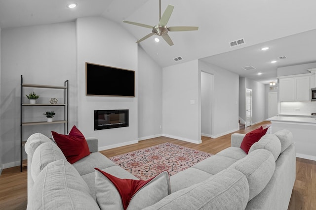 10650 Barrington Ln, Fort Worth, TX 76126 - living area featuring a ceiling fan, lofted ceiling, recessed lighting, a glass covered fireplace, and light wood-style flooring
