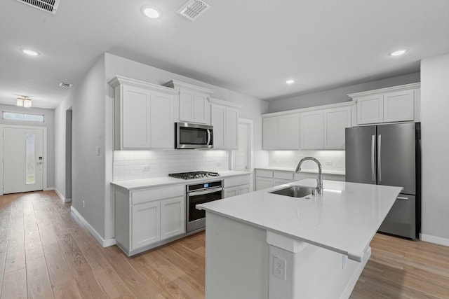 10650 Barrington Ln, Fort Worth, TX 76126 - kitchen featuring appliances with stainless steel finishes, white cabinetry, tasteful backsplash, light countertops, and light wood-style floors