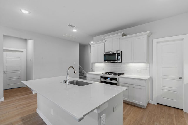 10650 Barrington Ln, Fort Worth, TX 76126 - kitchen featuring appliances with stainless steel finishes, light wood-style flooring, white cabinets, decorative backsplash, and recessed lighting