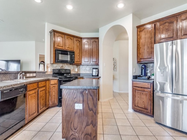 1071 Shepard Ln, Lavon, TX 75166 - kitchen featuring black appliances, a sink, decorative backsplash, arched walkways, and light tile patterned floors