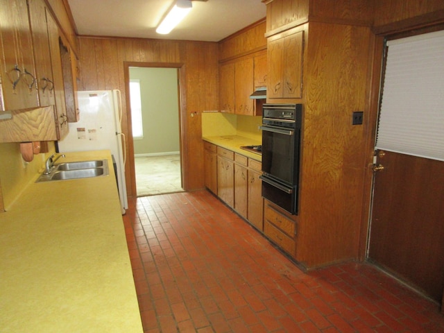611 W 4th St, Homer, LA 71040 - kitchen with a sink, a warming drawer, wood walls, light countertops, and brown cabinets