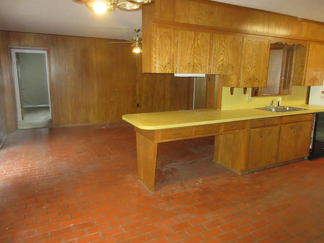 611 W 4th St, Homer, LA 71040 - kitchen featuring a sink, wood walls, brick flooring, brown cabinetry, and light countertops