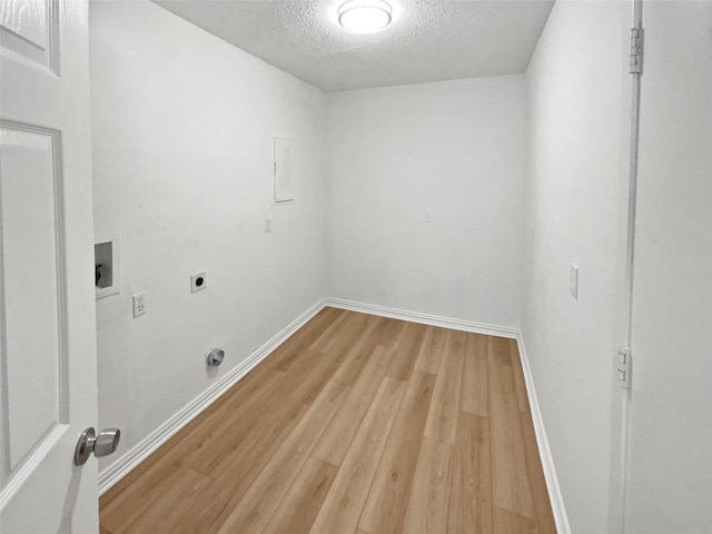 7620 Clover Ln, Watauga, TX 76148 - washroom with electric dryer hookup, light wood-style floors, a textured ceiling, hookup for a washing machine, and baseboards