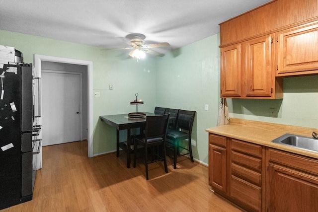 2311 Anderson St, Irving, TX 75062 - kitchen with light wood-style floors, a ceiling fan, light countertops, and freestanding refrigerator