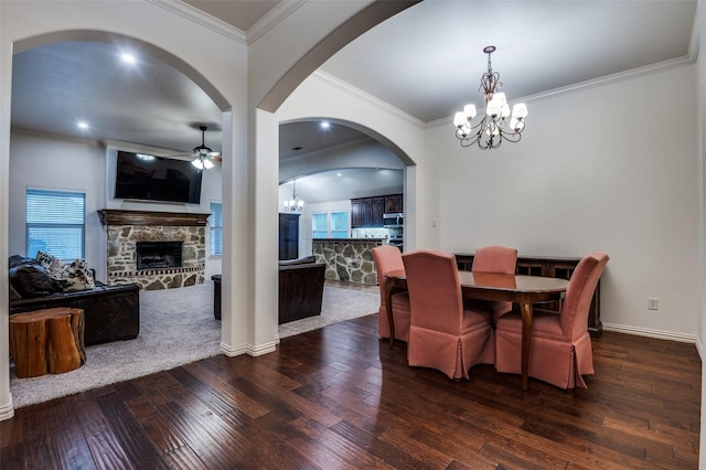 101 Aucuba Ln, Waxahachie, TX 75165 - dining space featuring a chandelier, a ceiling fan, a stone fireplace, wood-type flooring, and arched walkways