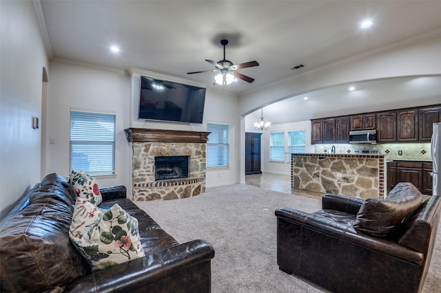 101 Aucuba Ln, Waxahachie, TX 75165 - living area featuring arched walkways, a chandelier, a ceiling fan, a stone fireplace, and light carpet