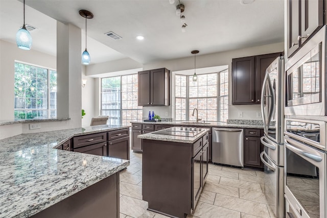 4037 Azure Ln, Addison, TX 75001 - kitchen featuring stainless steel appliances, a sink, light stone counters, a center island, and dark brown cabinets