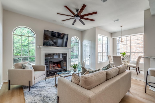 4037 Azure Ln, Addison, TX 75001 - living area with light wood-style floors, a ceiling fan, a premium fireplace, a chandelier, and baseboards