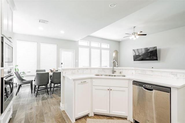 1507 Calcot Ln, Forney, TX 75126 - kitchen featuring appliances with stainless steel finishes, a sink, light wood-type flooring, light countertops, and white cabinetry