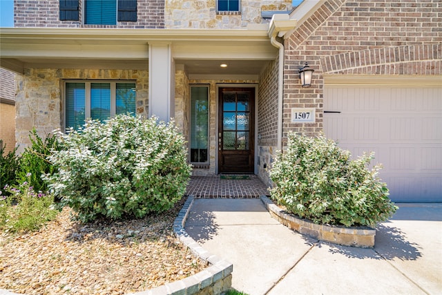 1507 Calcot Ln, Forney, TX 75126 - view of exterior entry featuring an attached garage, covered porch, stone siding, and brick siding