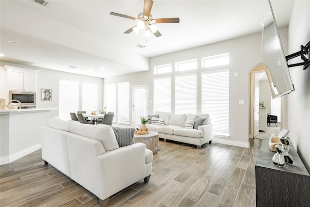 1507 Calcot Ln, Forney, TX 75126 - living area featuring arched walkways, light wood-type flooring, ceiling fan, recessed lighting, and baseboards