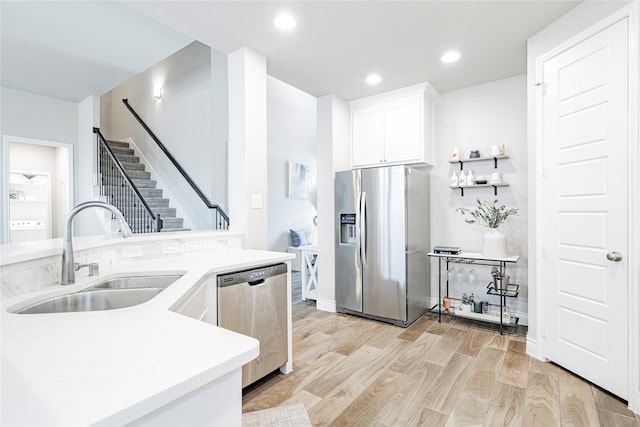 1507 Calcot Ln, Forney, TX 75126 - kitchen featuring appliances with stainless steel finishes, a sink, washer / dryer, white cabinets, and light wood-type flooring