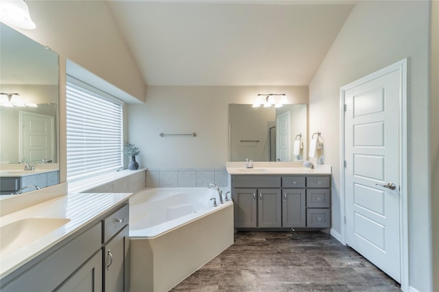 293 Cisco Trl, Forney, TX 75126 - full bathroom with two vanities, a bath, lofted ceiling, and wood finished floors