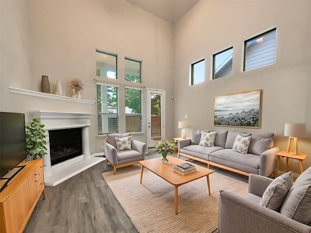 716 Setting Sun Trl, Mckinney, TX 75069 - living area with a towering ceiling, dark wood-style floors, and a fireplace with raised hearth