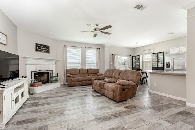 1253 Stone Ln, Celina, TX 75009 - living area with a ceiling fan, light wood-type flooring, a brick fireplace, and baseboards