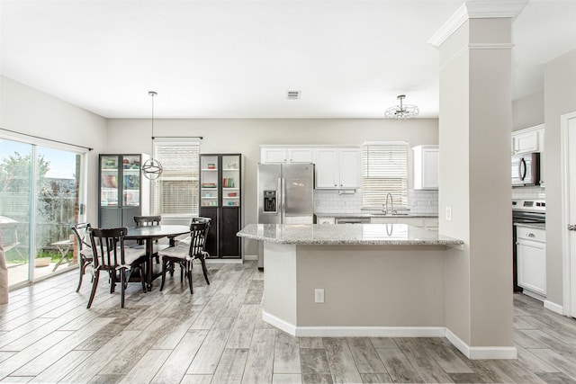 1253 Stone Ln, Celina, TX 75009 - kitchen with appliances with stainless steel finishes, a sink, light wood-style flooring, decorative backsplash, and white cabinets