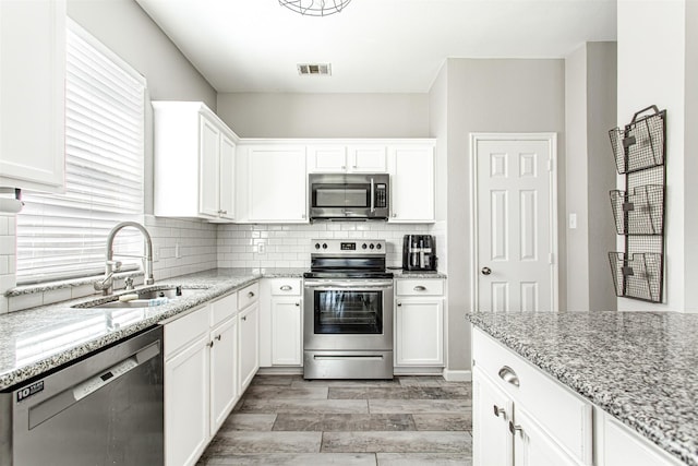 1253 Stone Ln, Celina, TX 75009 - kitchen featuring appliances with stainless steel finishes, a sink, backsplash, and white cabinets