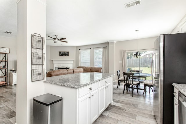 1253 Stone Ln, Celina, TX 75009 - kitchen with freestanding refrigerator, a ceiling fan, open floor plan, a fireplace, and white cabinetry