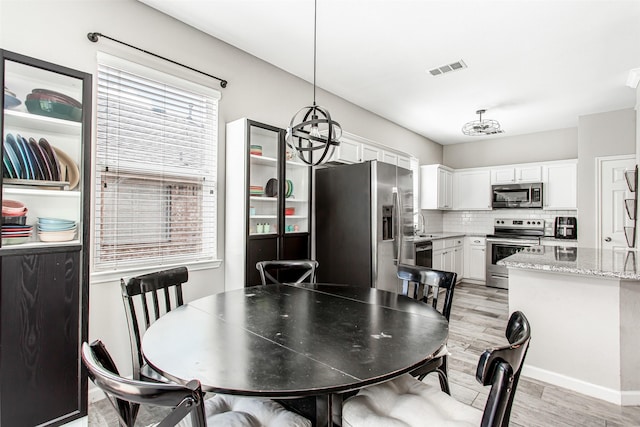 1253 Stone Ln, Celina, TX 75009 - dining room with light wood finished floors and a chandelier