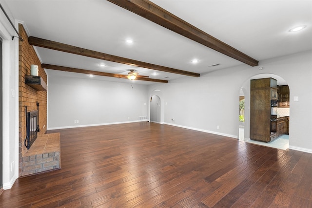 7624 Lake Highlands Dr, Fort Worth, TX 76179 - unfurnished living room featuring arched walkways, ceiling fan, a fireplace, wood-type flooring, and beamed ceiling