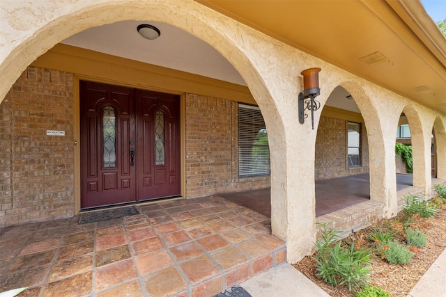 7624 Lake Highlands Dr, Fort Worth, TX 76179 - view of exterior entry with brick siding, stucco siding, and a porch