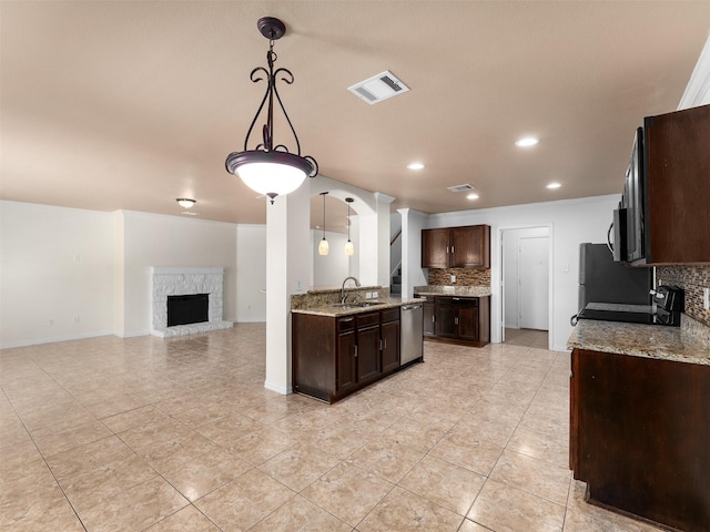 9849 Vickie Ln, Frisco, TX 75035 - kitchen with tasteful backsplash, appliances with stainless steel finishes, dark brown cabinetry, light tile patterned floors, and recessed lighting