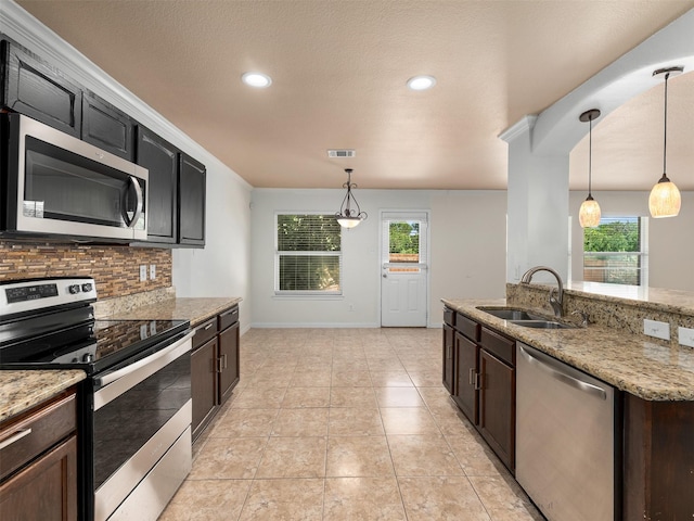 9849 Vickie Ln, Frisco, TX 75035 - kitchen with appliances with stainless steel finishes, a sink, backsplash, healthy amount of natural light, and recessed lighting