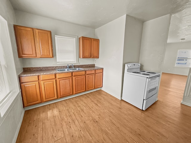 109 S 5th St, Sanger, TX 76266 - kitchen featuring white electric range, light wood finished floors, a sink, and brown cabinets