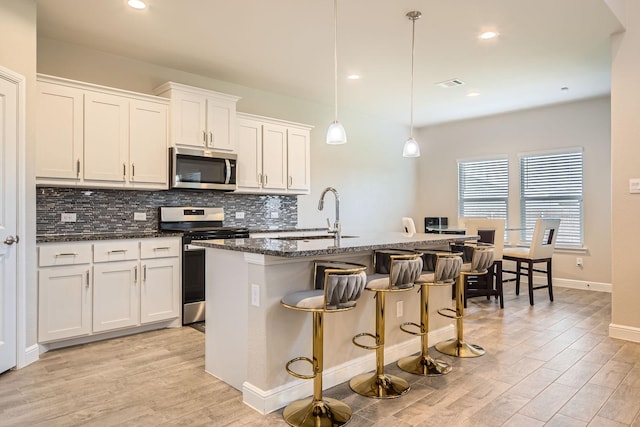 1225 Elmwood Dr, Cedar Hill, TX 75104 - kitchen featuring stainless steel appliances, a sink, backsplash, light wood-style floors, and recessed lighting