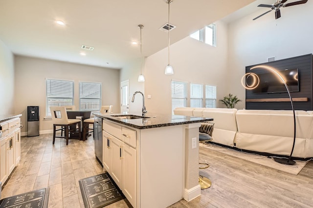 1225 Elmwood Dr, Cedar Hill, TX 75104 - kitchen with a sink, dark stone counters, light wood-style flooring, white cabinets, and recessed lighting