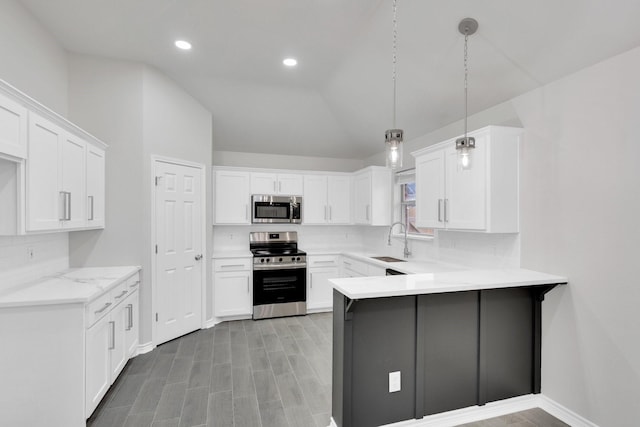 307 Pebble Creek Ln, Red Oak, TX 75154 - kitchen featuring appliances with stainless steel finishes, a sink, a peninsula, tasteful backsplash, and white cabinets