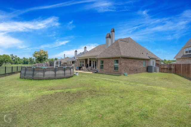 1029 Spanish Moss Cir, Bossier City, LA 71111 - back of property with a chimney, brick siding, roof with shingles, and central AC