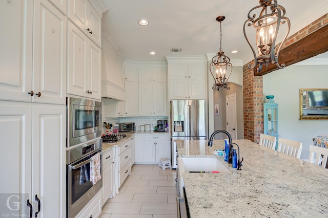 1029 Spanish Moss Cir, Bossier City, LA 71111 - kitchen with stainless steel appliances, a chandelier, a sink, crown molding, and white cabinetry