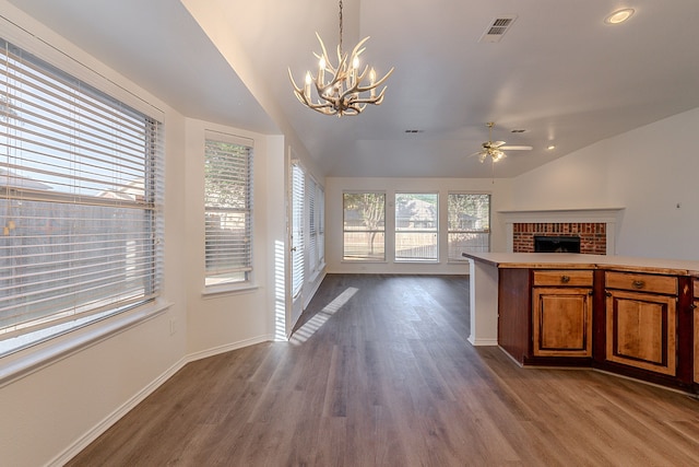 7028 Herman Jared Dr, North Richland Hills, TX 76182 - unfurnished living room featuring vaulted ceiling, a chandelier, dark wood-style flooring, baseboards, and a brick fireplace