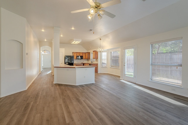 7028 Herman Jared Dr, North Richland Hills, TX 76182 - kitchen with open floor plan, brown cabinets, a sink, wood finished floors, and decorative backsplash