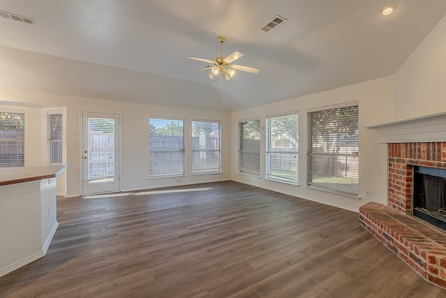 7028 Herman Jared Dr, North Richland Hills, TX 76182 - unfurnished living room with ceiling fan, a brick fireplace, vaulted ceiling, dark wood-type flooring, and baseboards
