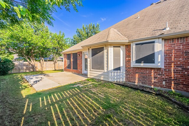 7028 Herman Jared Dr, North Richland Hills, TX 76182 - rear view of house featuring brick siding, a patio area, and roof with shingles