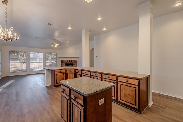 7028 Herman Jared Dr, North Richland Hills, TX 76182 - kitchen with a center island, open floor plan, ceiling fan, a brick fireplace, and wood finished floors