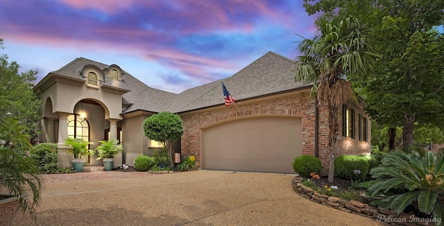 129 Carondelet Ct, Bossier City, LA 71111 - french country inspired facade featuring concrete driveway, an attached garage, brick siding, roof with shingles, and stucco siding