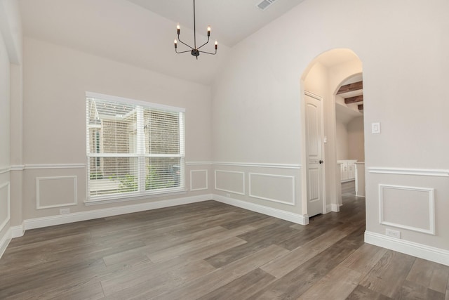 302 Micco Ln, Rockwall, TX 75087 - unfurnished dining area featuring vaulted ceiling, arched walkways, a chandelier, wood finished floors, and a decorative wall