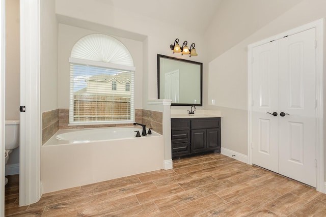 302 Micco Ln, Rockwall, TX 75087 - full bath with a garden tub, vanity, toilet, wood finished floors, and vaulted ceiling